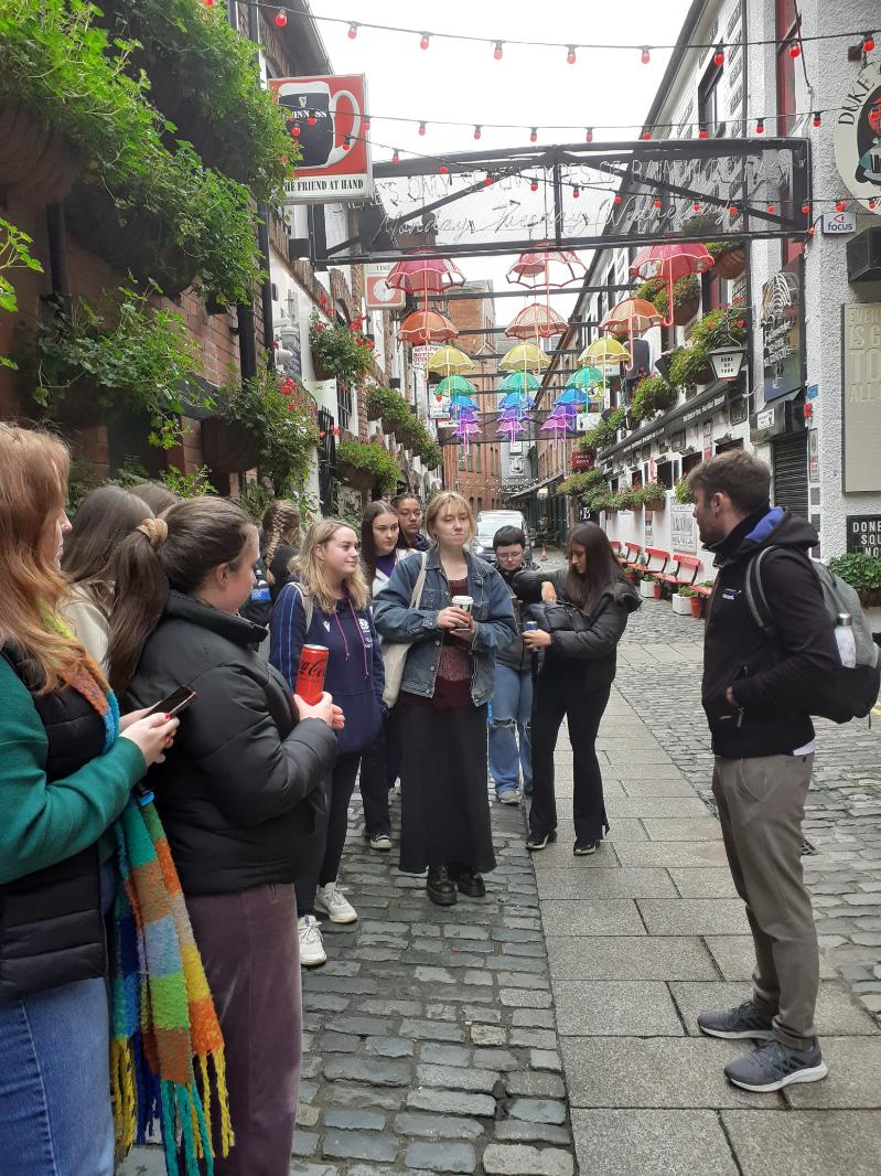 a group of students standing with tour guide in Commercial Court, Belfast